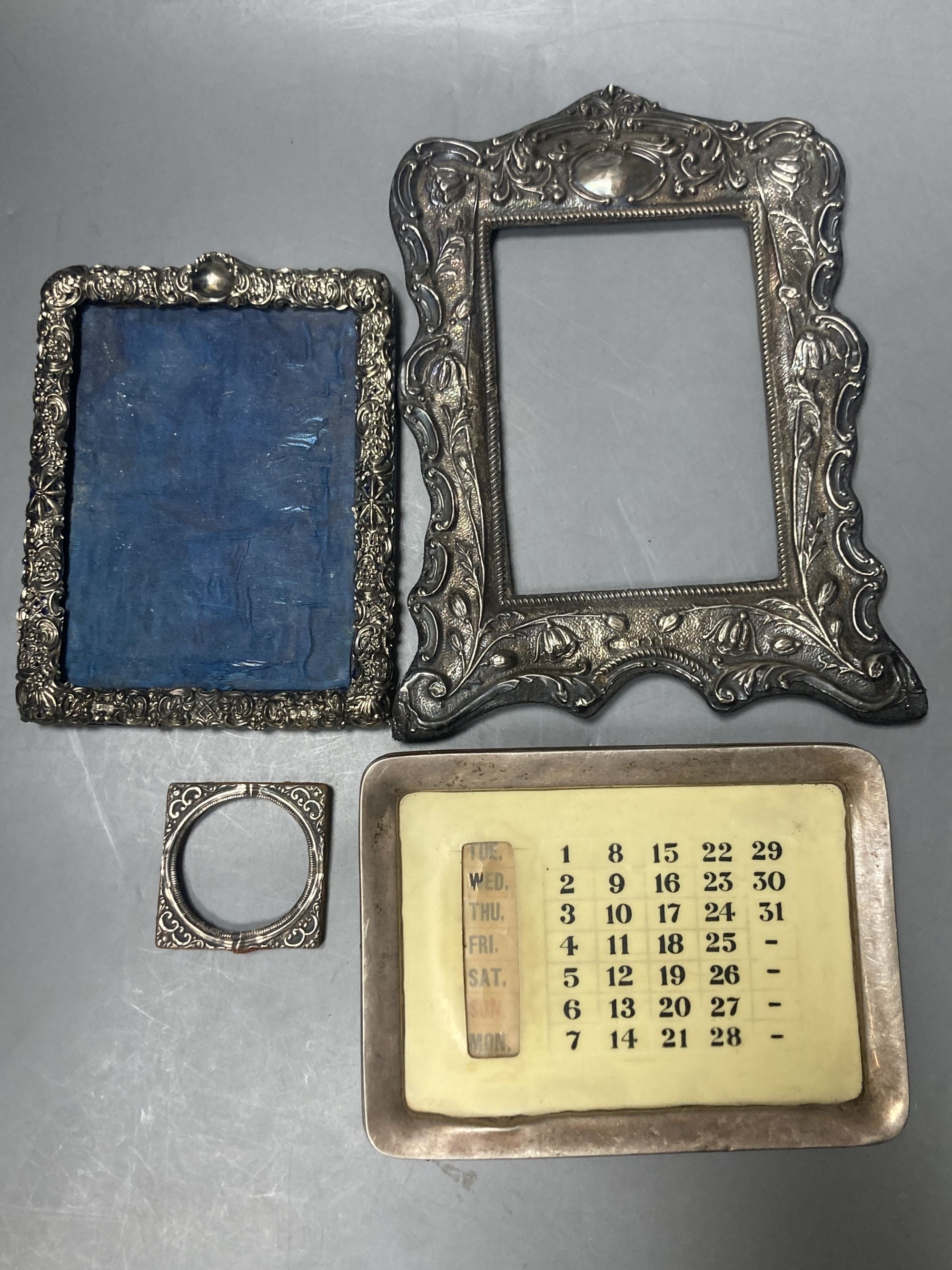 A george V silver mounted desk calendar and three late 19th/early 20th century silver mounted photograph frames,